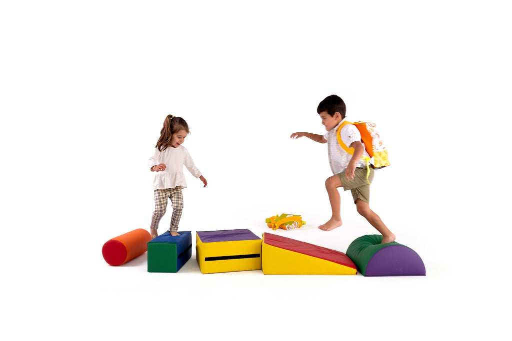 Two young children playing on colourful foam blocks, with one wearing a TWO CUBS backpack. A fun, screen-free activity promoting creativity and active play.