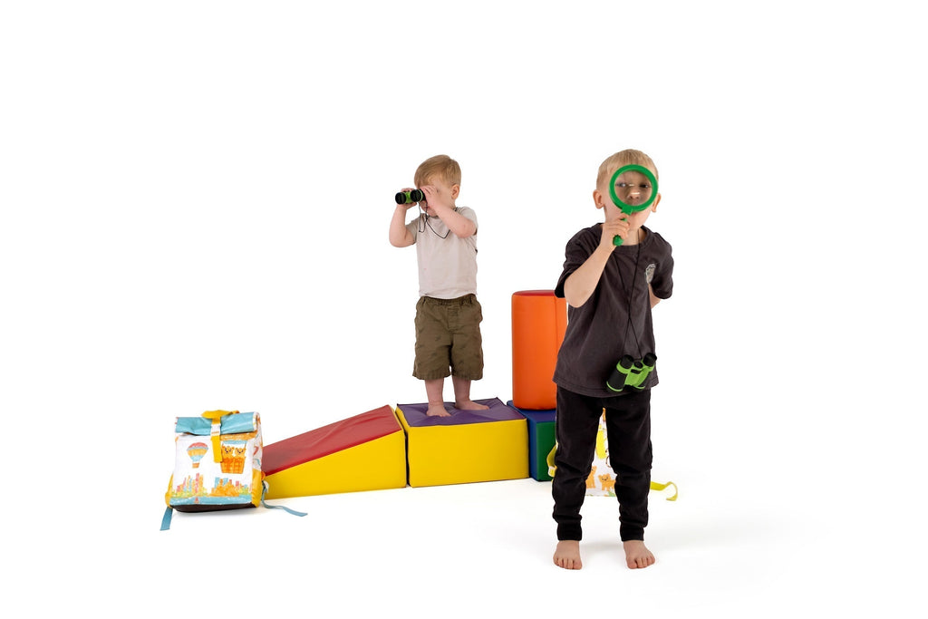 Two kids exploring, alongside a colourful TWO CUBS kids backpack
