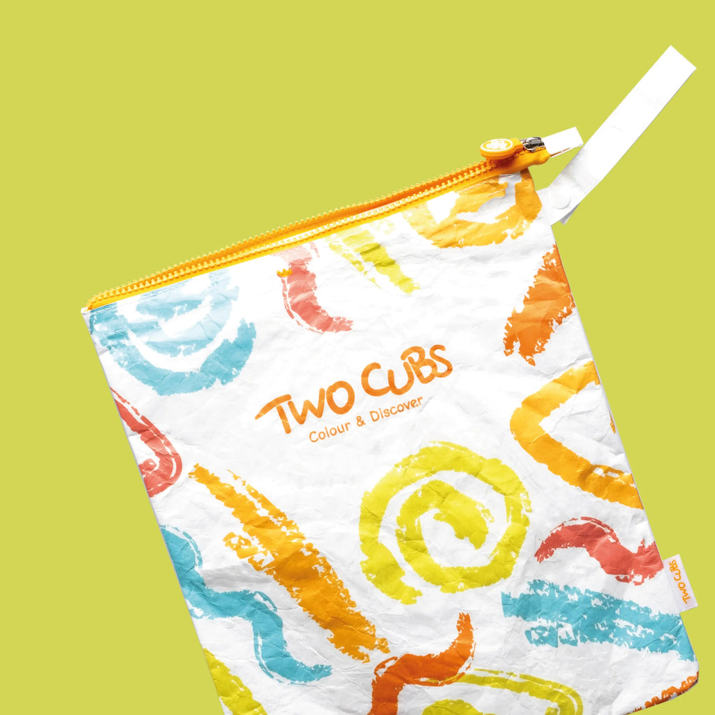 Two Cubs eco-friendly wet bag with colorful abstract prints and a yellow zipper on a green background