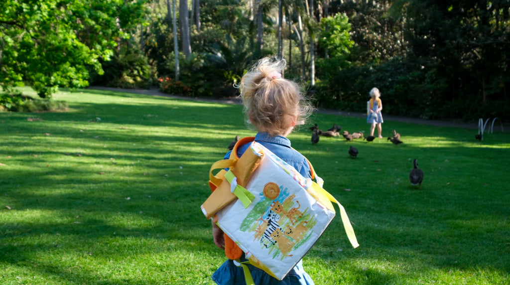 Child wearing the TWO CUBS Safari Backpack, ideal for family travel, day trips, and carrying toys, snacks, and activity kits